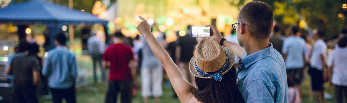 couple at outdoor venue facing away from the camera pointing up